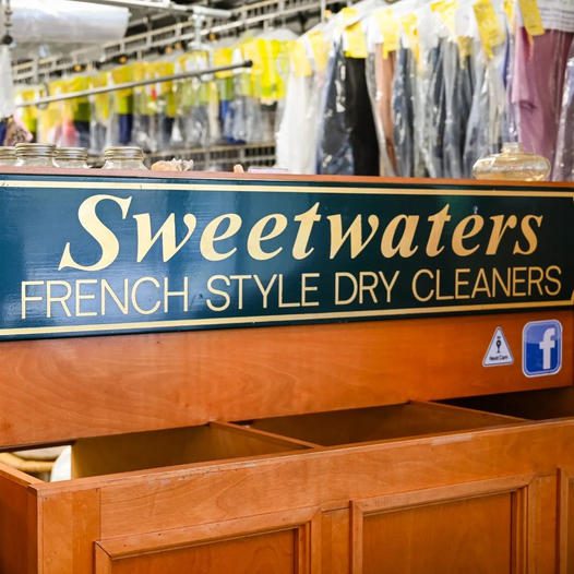A sign for sweetwaters french style dry cleaners.